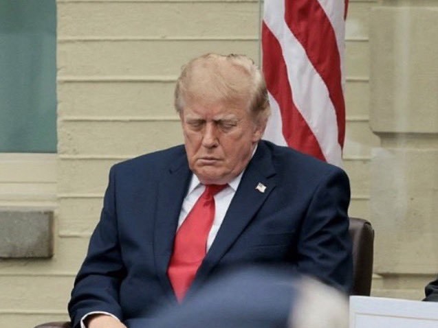 Donald Trump seated with his eyes closed at the Pentagon 9/11 event.